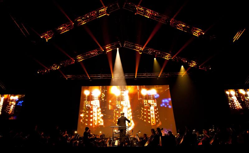 Daleks on the screen while Ben Foster conducts the BBC National Orchestra of Wales and the BBC National Chorus of Wales. Image: House PR