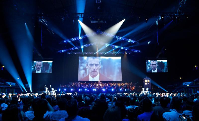 The Doctor Peter Capaldi on the screen while Ben Foster conducts the BBC National Orchestra of Wales and the BBC National Chorus of Wales as Cybermen invade the audience. Image: House PR